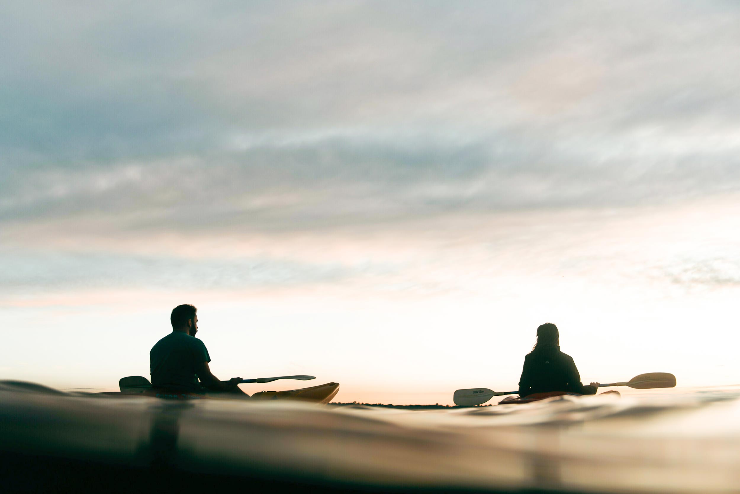 Two people in kayaks on the water.