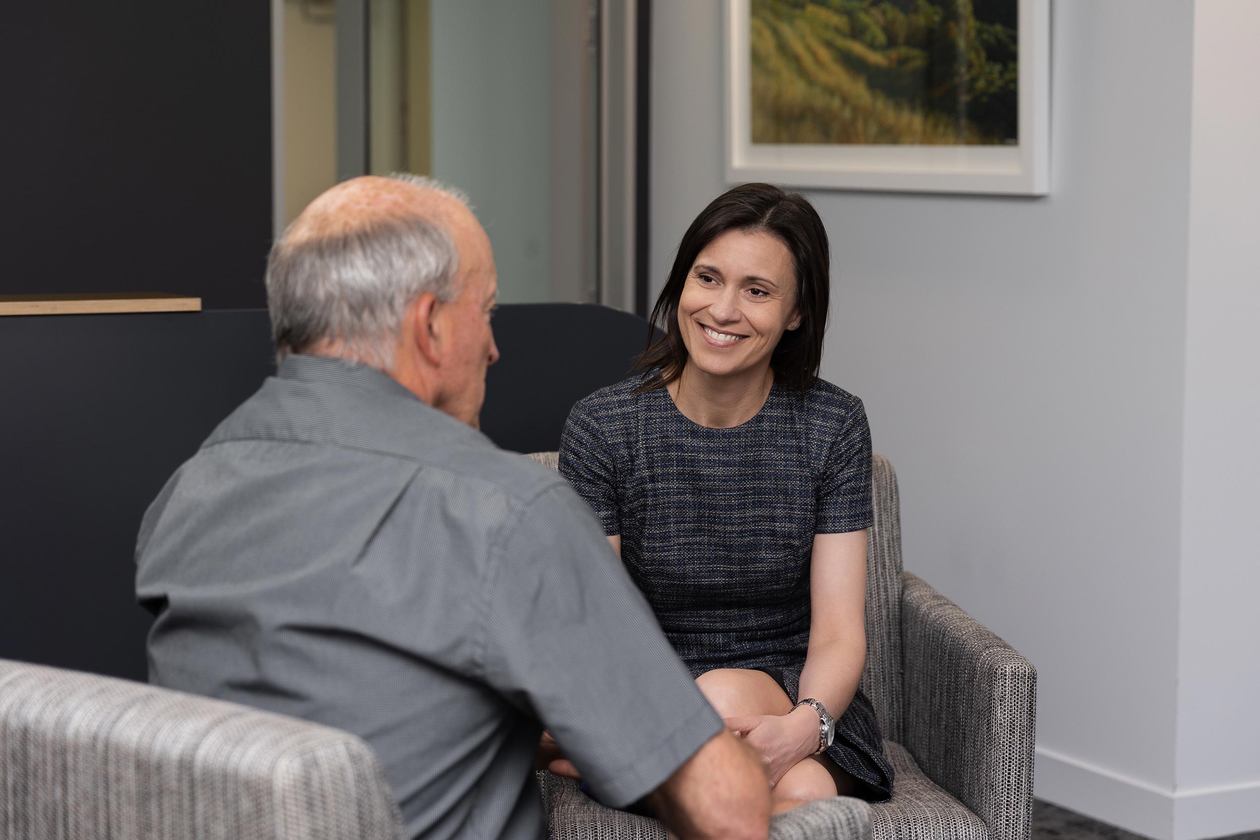 Lawyer and client sitting in office lounge chairs having a discussion